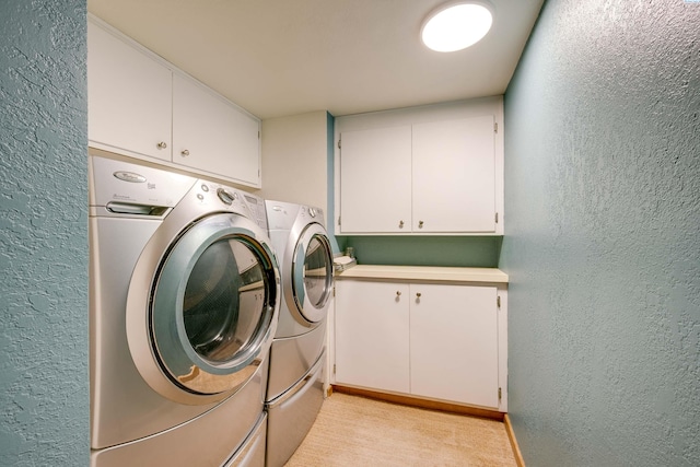 washroom featuring a textured wall and washing machine and dryer