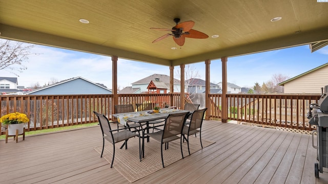 wooden deck featuring outdoor dining area and a ceiling fan