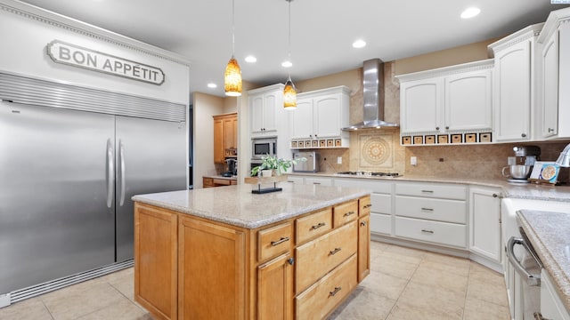 kitchen with backsplash, white cabinets, wall chimney range hood, light tile patterned floors, and built in appliances