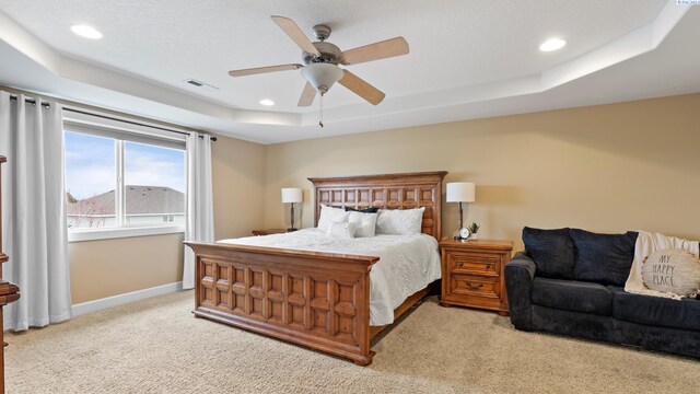 bedroom featuring visible vents, baseboards, recessed lighting, light carpet, and a raised ceiling