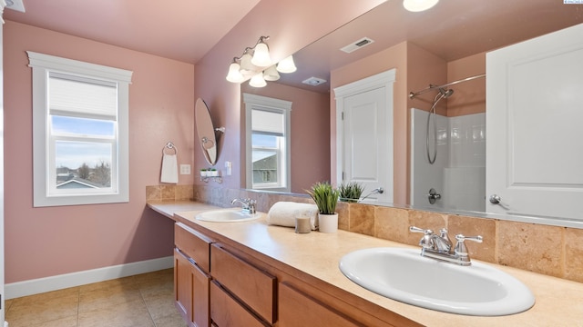 bathroom featuring a sink, visible vents, baseboards, and tile patterned flooring