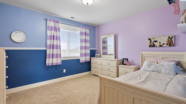 bedroom with a textured ceiling, light colored carpet, visible vents, and baseboards