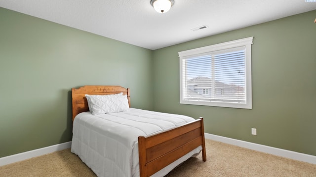 carpeted bedroom with visible vents and baseboards