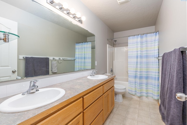 full bath with a textured ceiling, shower / bath combo, a sink, and toilet