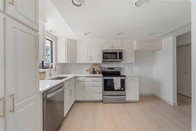 1819 Newport St, Kennewick, WA 99337 - kitchen with appliances with stainless steel finishes, a sink, light wood-style floors, white cabinetry, and recessed lighting