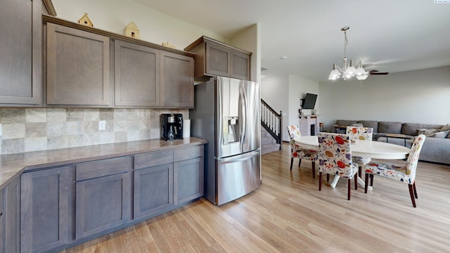 1025 SW Corral Ct, Pullman, WA 99163 - kitchen with stainless steel fridge with ice dispenser, light wood-type flooring, backsplash, open floor plan, and a chandelier
