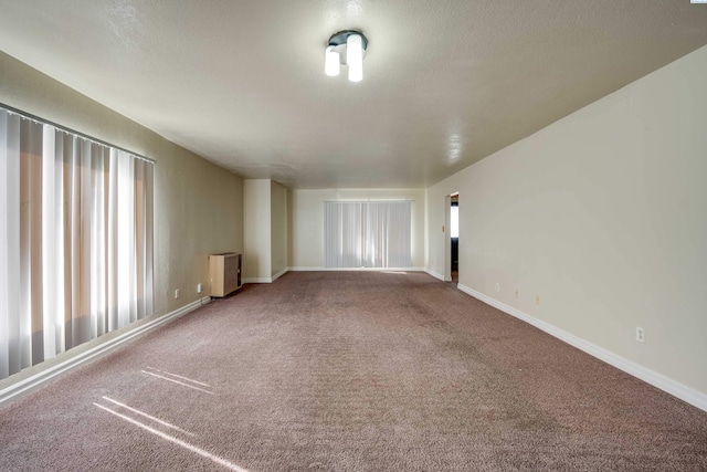 spare room with carpet floors, radiator heating unit, and a textured ceiling