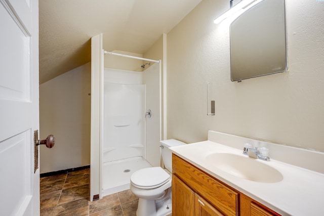 bathroom with vanity, lofted ceiling, toilet, and a shower