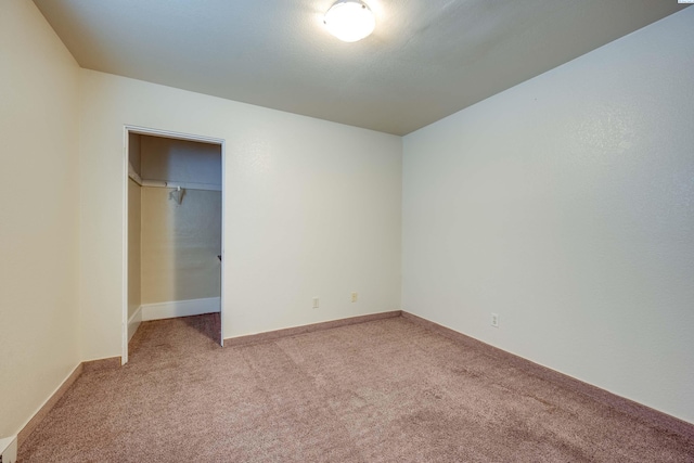 unfurnished bedroom featuring light carpet, a spacious closet, and a closet