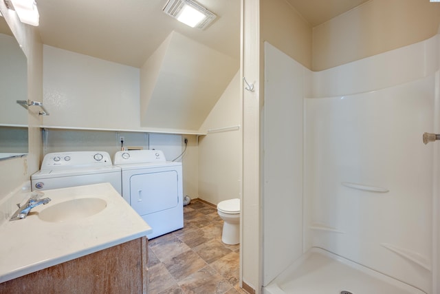 bathroom featuring walk in shower, toilet, separate washer and dryer, vaulted ceiling, and vanity