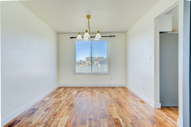 4210 Cornish Ln, Pasco, WA 99301 - unfurnished dining area with a notable chandelier, baseboards, and wood finished floors