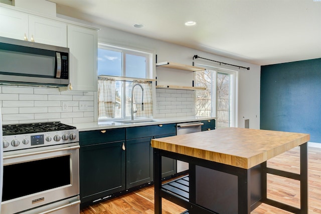 4210 Cornish Ln, Pasco, WA 99301 - kitchen featuring tasteful backsplash, light wood-type flooring, appliances with stainless steel finishes, wood counters, and a sink
