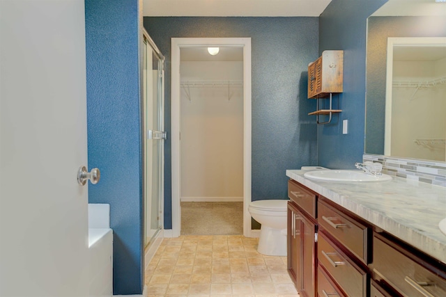 4210 Cornish Ln, Pasco, WA 99301 - full bathroom featuring double vanity, a sink, a shower stall, toilet, and backsplash