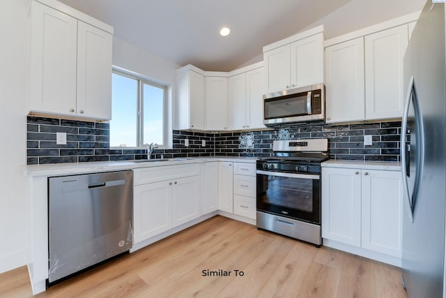 1610 Diamond Ave, Grandview, WA 98930 - kitchen with stainless steel appliances, light countertops, light wood-type flooring, white cabinets, and recessed lighting