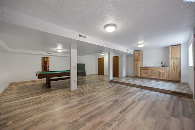 10012 Maple Dr, Pasco, WA 99301 - below grade area with a sink, a textured ceiling, billiards, light wood-style floors, and baseboards