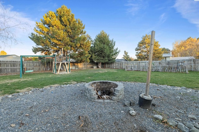 view of yard featuring a playground and an outdoor fire pit