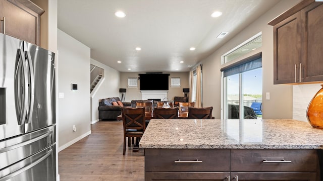 2955 S Kellogg St, Kennewick, WA 99338 - kitchen featuring stainless steel fridge with ice dispenser, recessed lighting, wood finished floors, light stone countertops, and dark brown cabinets
