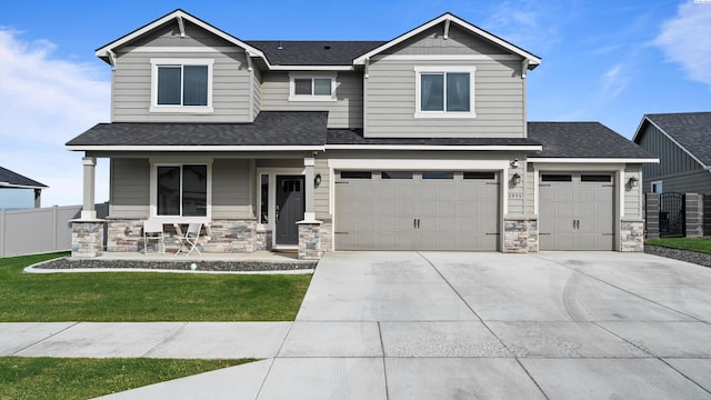 2955 S Kellogg St, Kennewick, WA 99338 - craftsman house with covered porch, stone siding, a shingled roof, concrete driveway, and a garage