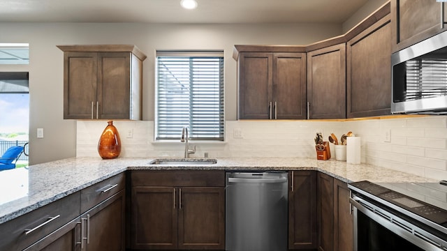 2955 S Kellogg St, Kennewick, WA 99338 - kitchen with appliances with stainless steel finishes, a sink, backsplash, light stone counters, and recessed lighting