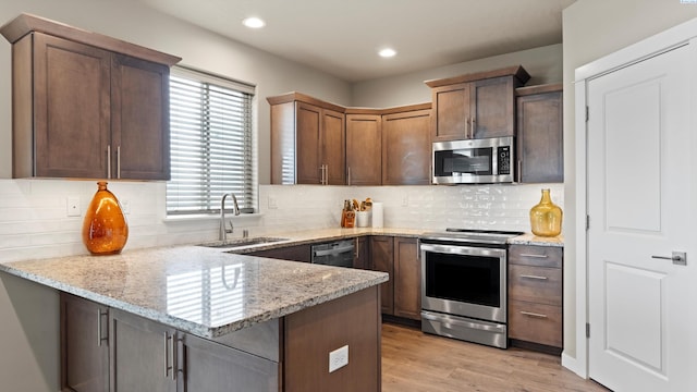 2955 S Kellogg St, Kennewick, WA 99338 - kitchen featuring appliances with stainless steel finishes, a sink, a peninsula, light stone countertops, and recessed lighting