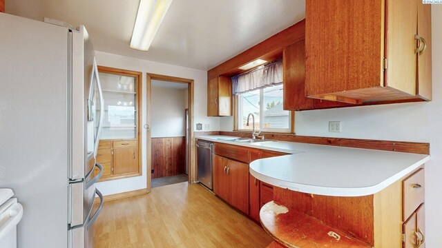 703 W Octave St, Pasco, WA 99301 - kitchen with appliances with stainless steel finishes, light wood-style flooring, brown cabinetry, light countertops, and a peninsula