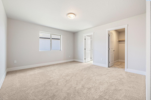 6563 W 30th Pl, Kennewick, WA 99338 - unfurnished bedroom with a closet, light colored carpet, a walk in closet, and baseboards
