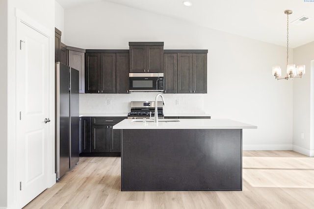 6563 W 30th Pl, Kennewick, WA 99338 - kitchen with backsplash, light countertops, vaulted ceiling, appliances with stainless steel finishes, and a sink