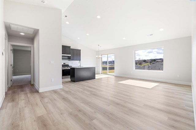 6563 W 30th Pl, Kennewick, WA 99338 - unfurnished living room featuring visible vents, high vaulted ceiling, an inviting chandelier, a sink, and light wood-style floors