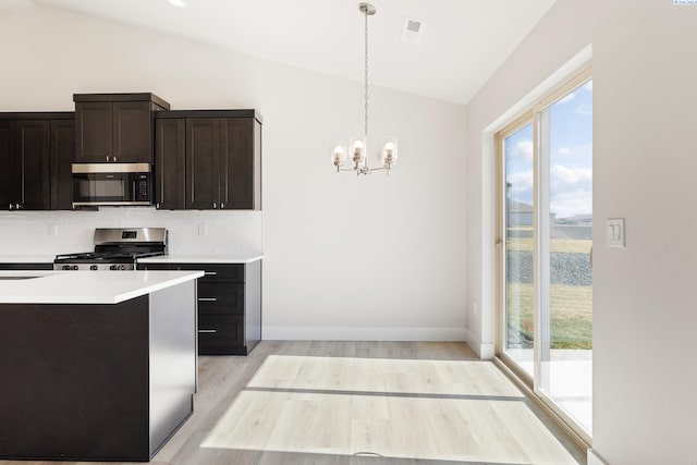 6563 W 30th Pl, Kennewick, WA 99338 - kitchen with lofted ceiling, plenty of natural light, stainless steel appliances, a notable chandelier, and backsplash
