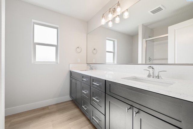 6563 W 30th Pl, Kennewick, WA 99338 - full bathroom featuring visible vents, a stall shower, a sink, wood finished floors, and baseboards
