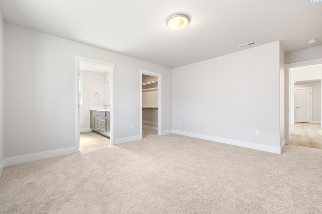 6563 W 30th Pl, Kennewick, WA 99338 - unfurnished bedroom with baseboards, visible vents, a spacious closet, a closet, and light carpet