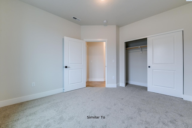 unfurnished bedroom featuring carpet floors, baseboards, and a closet