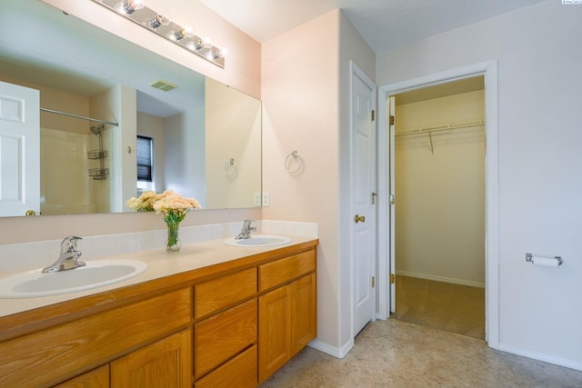 927 N Owen Ave, Pasco, WA 99301 - bathroom featuring double vanity, a shower, a walk in closet, and baseboards