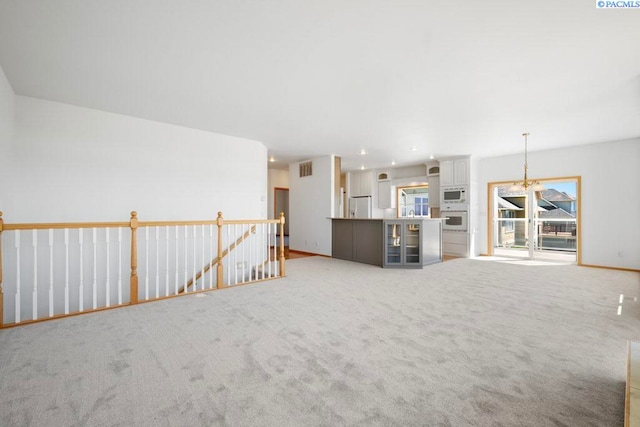 1815 NW Nicole Ct, Pullman, WA 99163 - unfurnished living room with light colored carpet and a chandelier