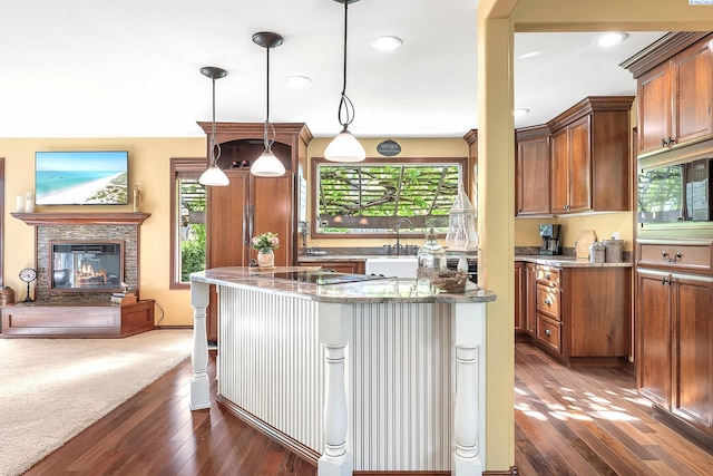 4834 W Robin Ct, West Richland, WA 99353 - kitchen featuring plenty of natural light, light stone countertops, dark wood-style flooring, and recessed lighting