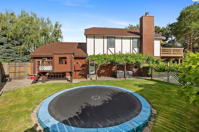 4834 W Robin Ct, West Richland, WA 99353 - rear view of property with a trampoline, a shingled roof, a gate, a chimney, and a wooden deck