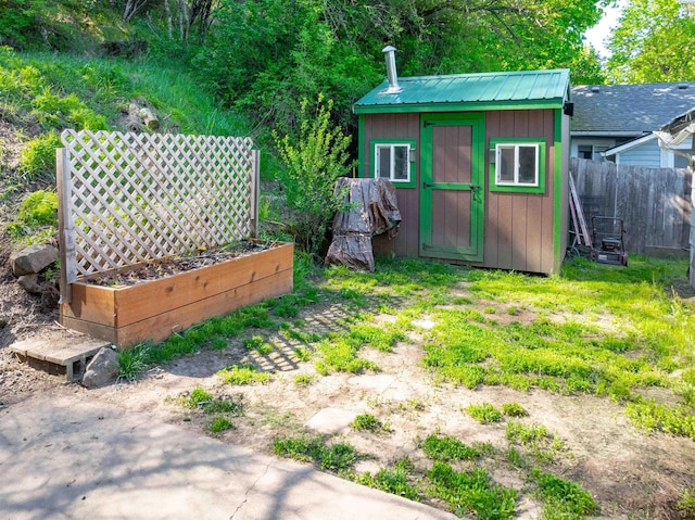 view of shed with fence and a garden