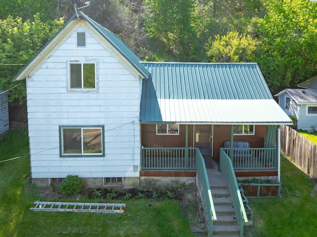 back of property featuring metal roof, covered porch, and stairway