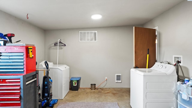 clothes washing area featuring visible vents, laundry area, heating unit, carpet floors, and washing machine and clothes dryer