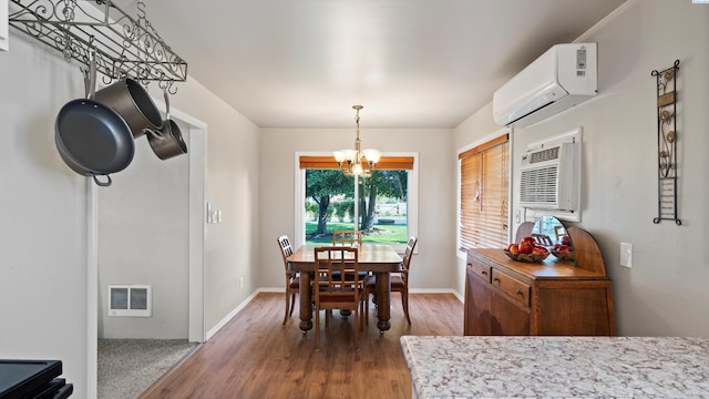 dining space featuring an AC wall unit, wood finished floors, a chandelier, and visible vents