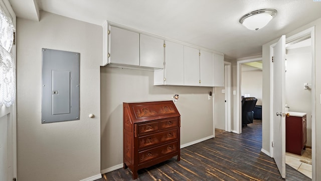 hallway with baseboards, electric panel, and dark wood finished floors