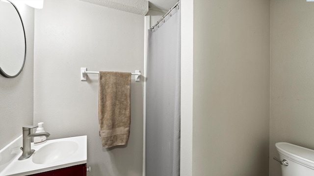 bathroom with toilet, a shower with shower curtain, and vanity
