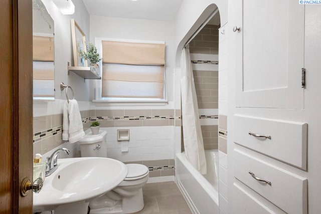 1005 NW State St, Pullman, WA 99163 - full bath with a sink, toilet, tile patterned floors, shower / bath combo with shower curtain, and tile walls
