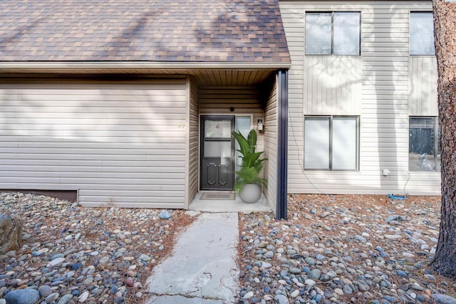 doorway to property with roof with shingles