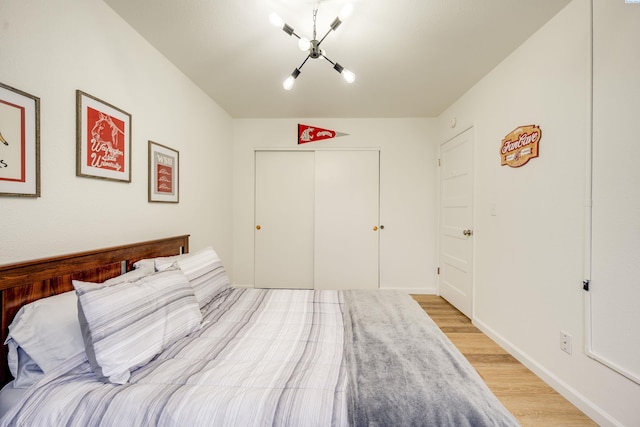 bedroom featuring light wood-style floors, baseboards, and a closet