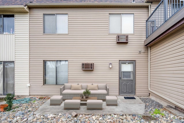 doorway to property featuring a balcony, a patio area, a shingled roof, and an outdoor hangout area