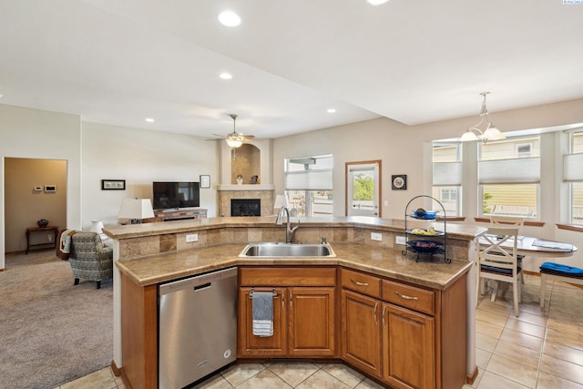 8712 W 9th Ave, Kennewick, WA 99336 - kitchen featuring stainless steel dishwasher, open floor plan, a fireplace, brown cabinets, and ceiling fan
