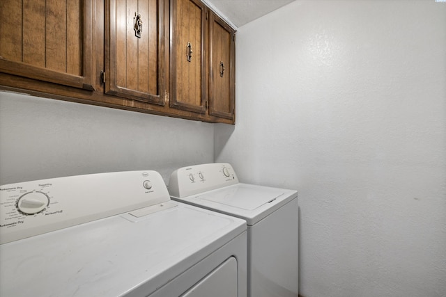 washroom featuring cabinets and washing machine and clothes dryer