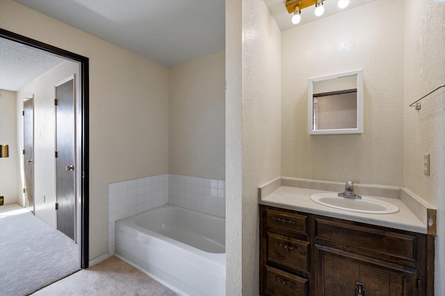 bathroom with vanity, tile patterned floors, a textured ceiling, and a tub to relax in