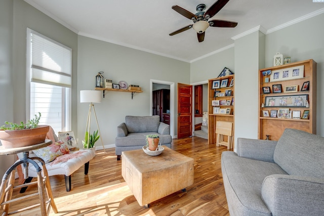 living area with a ceiling fan, light wood-type flooring, and ornamental molding